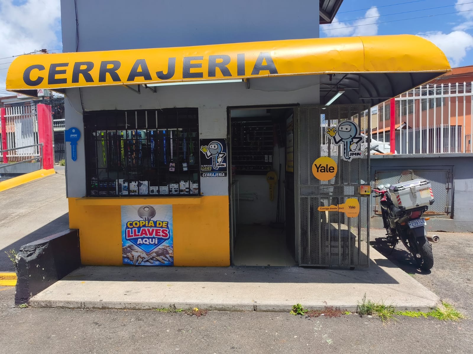 Local de Multi-Cerrajería Express con rótulo amarillo de Cerrajería, duplicado de llaves y productos Yale y JMA